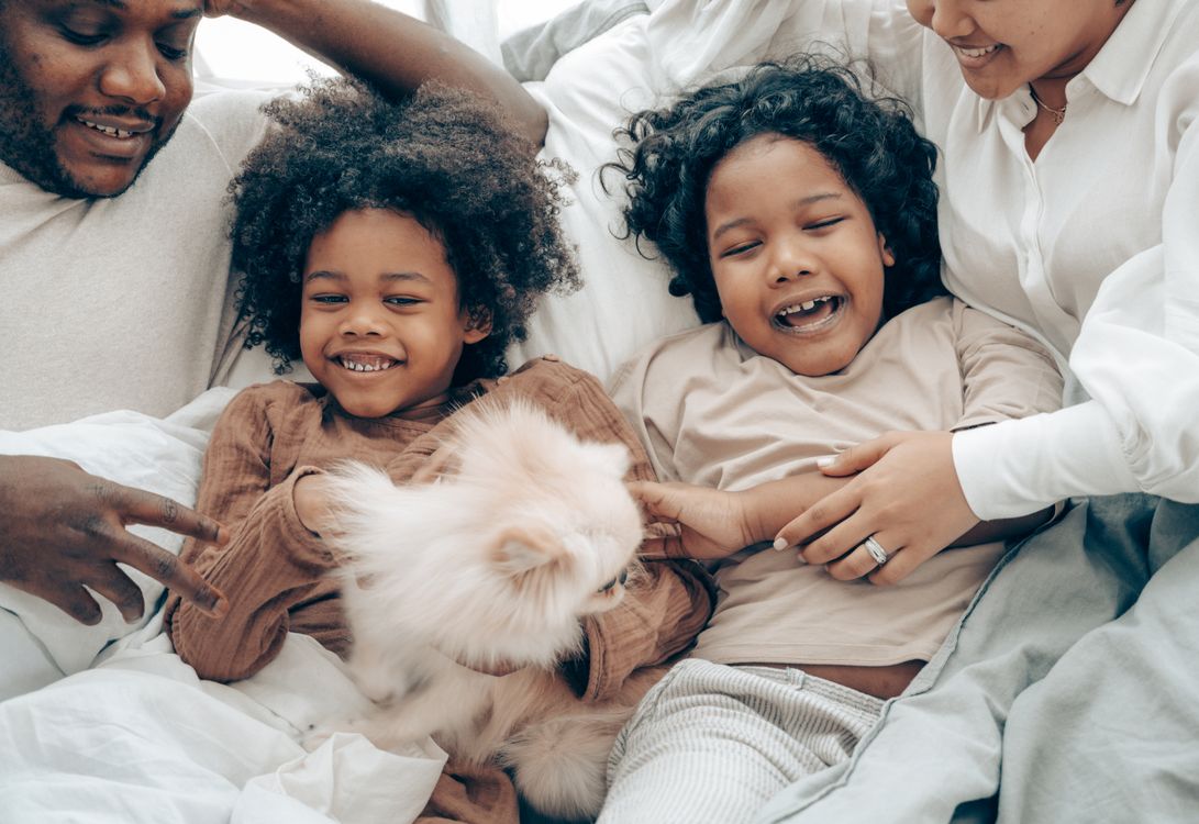 Family relaxing at home on the sofa with their dog