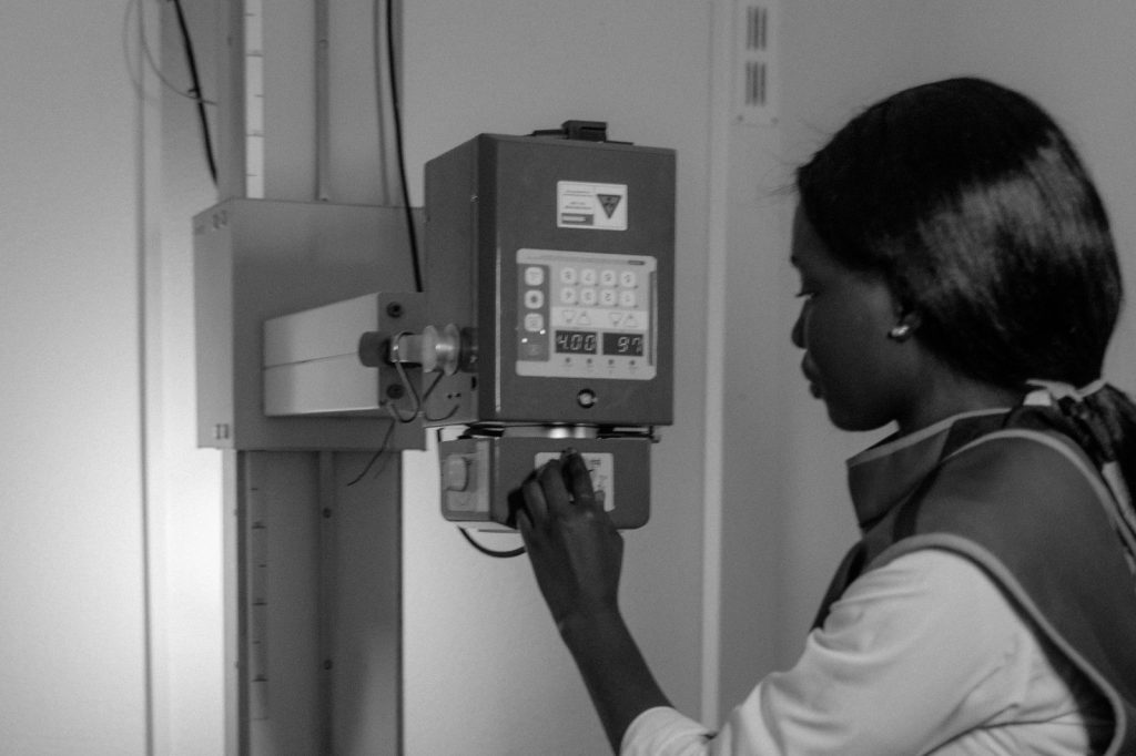 Veterinarian preparing a small dog for a chest X-ray at a clinic