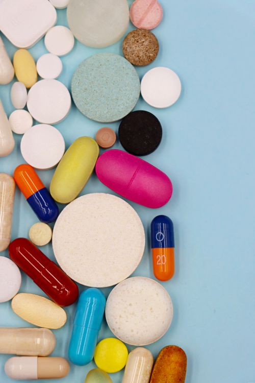 assorted pills and capsules arranged on a table