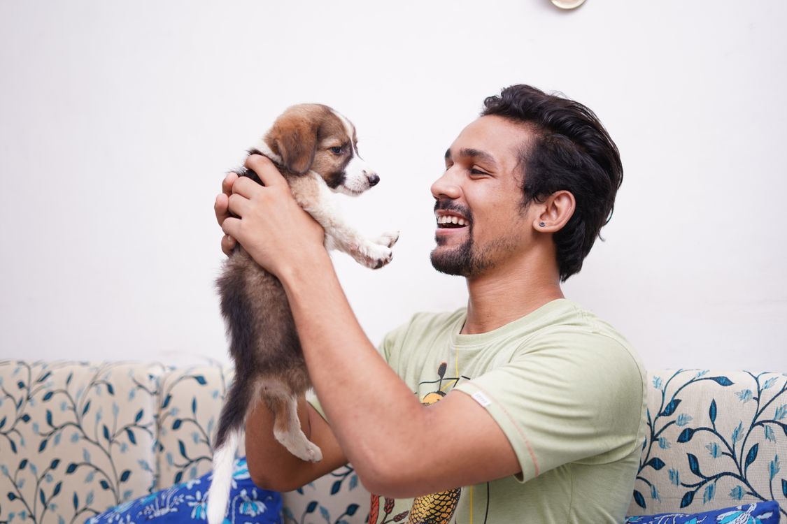 man holding a puppy in his arms