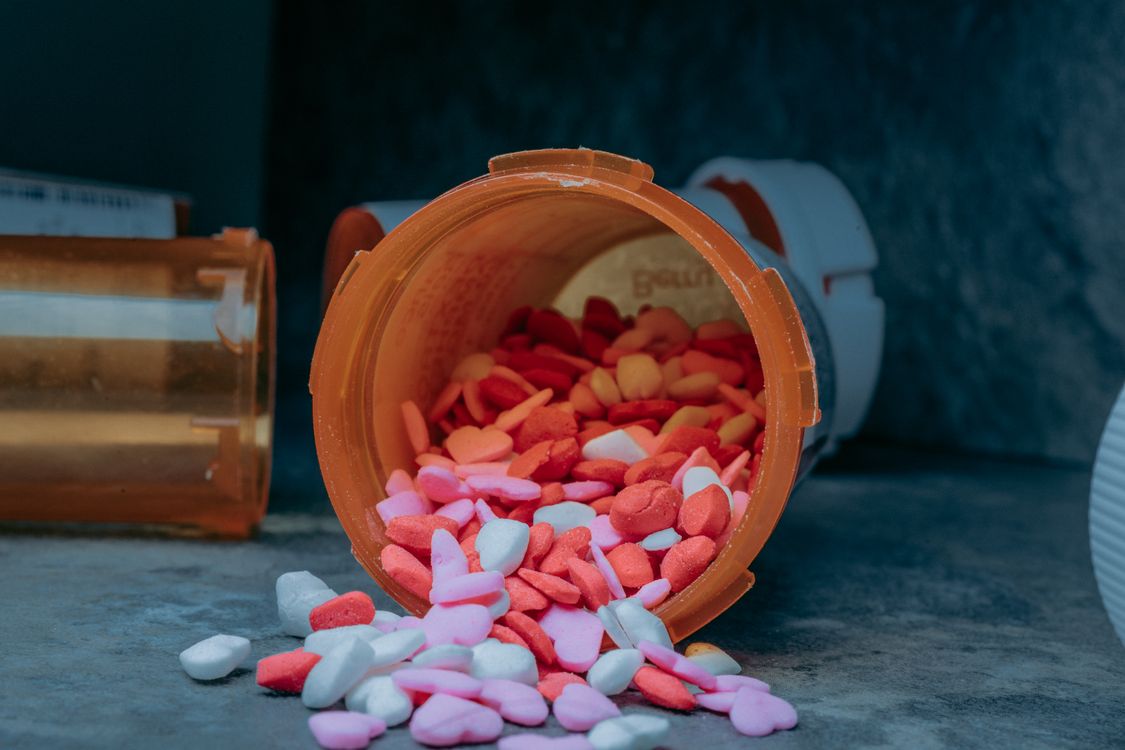 prescription pill bottle with tablets spilled onto a counter
