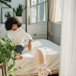 couple lying in bed with their dog between them in the morning