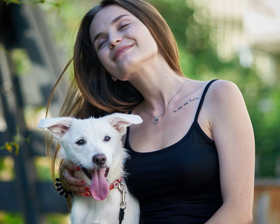 A woman hugging her dog outdoors